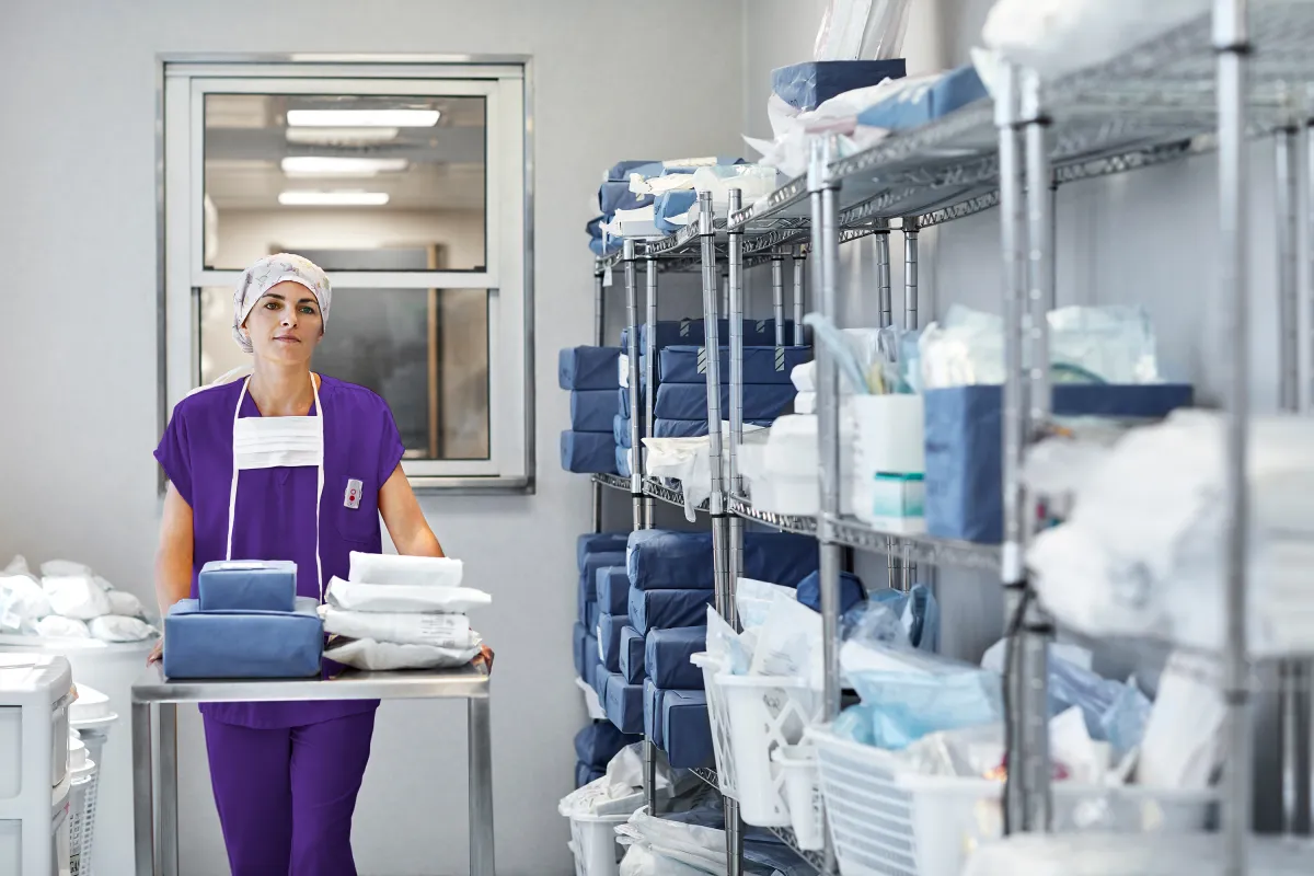 Hospital staff member organizing medical supplies in a storage room, illustrating inventory management and equipment visibility in healthcare.